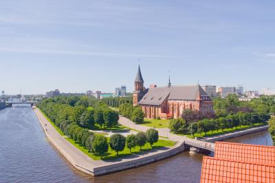 The old cathedral of Kaliningrad in Russia, a red-brick Gothic building surrounded by trees, used to introduce the idea of connecting different fields of knowledge.